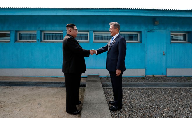 Voditelja Severne Koreje Kim Džong Un in Južne Koreje Mun Dže In sta si segla v roko. FOTO: AFP
