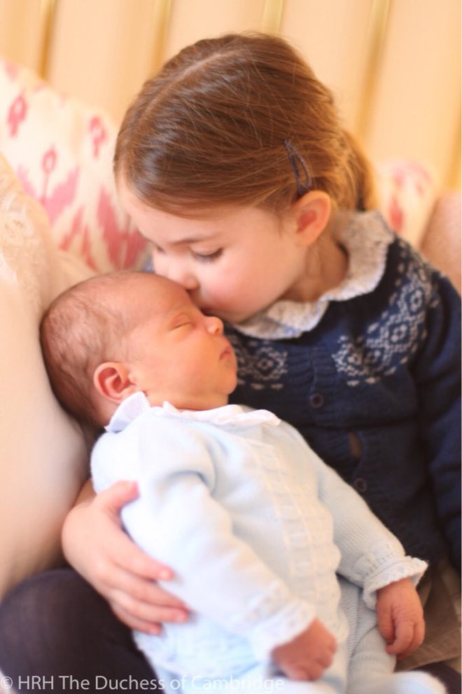 Spečemu malčku poljubček daje njegova sestrica, princesa Charlotte. FOTO: Kensingtonska Palača