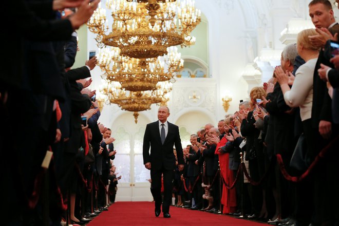 Vladimir Putin v špalirju gostov prihaja na svojo že četrto predsedniško inavguracijo. FOTO: Reuters