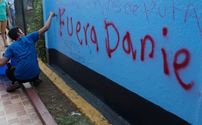 Moški z grafitom »Ven Daniel« predsednika Daniela Ortega poziva k odstopu. FOTO: Oswaldo Rivas/Reuters