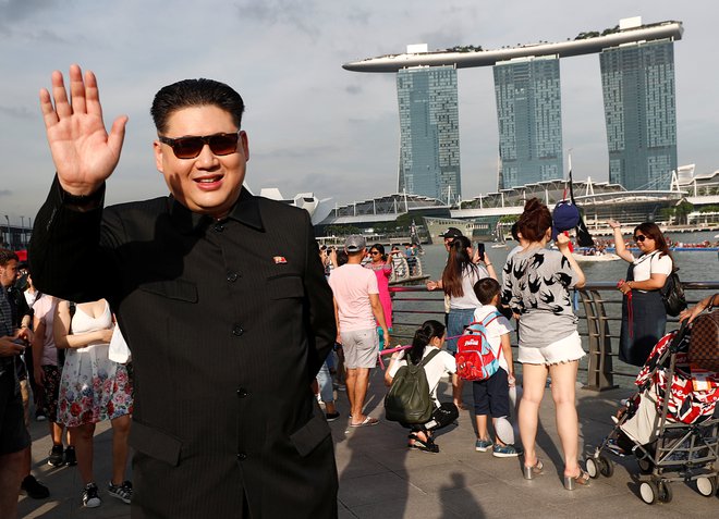 Howard X, Avstralec kitajskega rodu, ki je zelo podoben Kim Džong Unu, v parku Merlion v Singapurju pozdravlja mimoidoče. FOTO: Reuters