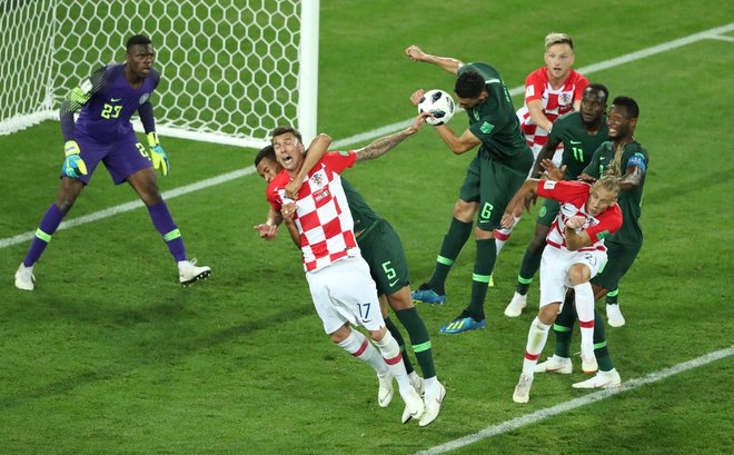 Najboljši igralec tekme Mario Mandžukić je priboril enajstmetrovko hrvaški reprezentanci, potem ko ga je takole objel Nigerijec William Troost-Ekong.<br />
FOTO: Reuters