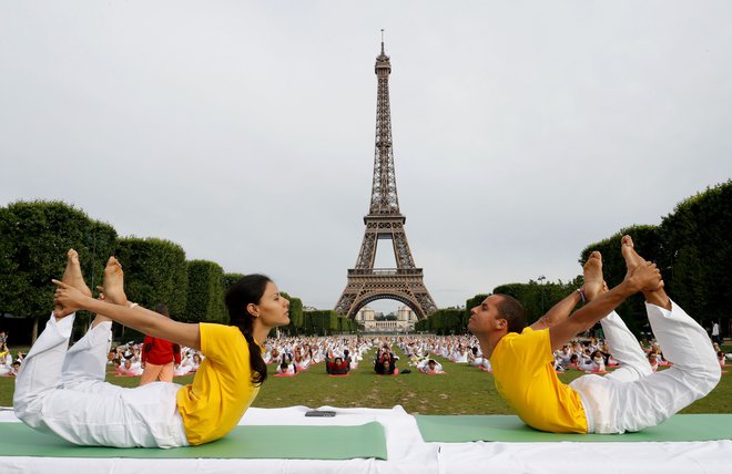 Pred prihajajočim mednarodnim dnevom joge 21. junija se po vsem svetu izvajajo brezplačne&nbsp;seanse joge na prostem. Utrinek izvajanja joge na travniku pred Eifflovim stolpom v Parizu.&nbsp;FOTO: Francois Guillot/AFP