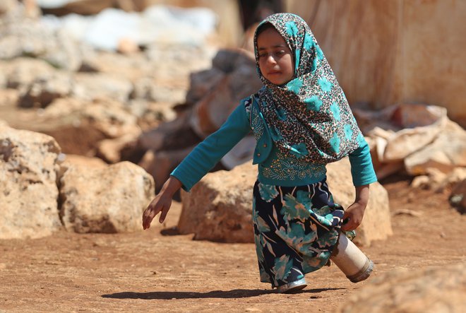 Portret osemletne sirske deklice Maye Mohammad Ali Merhi, ki se je rodila brez spodnjih udov. Ker ji družina ni mogla privoščiti pravih protetičnih udov, jih je oče naredil kar iz pločevink, napolnjenih z bombažem in ostankov krp. Njena družina je morala zaradi vojne zapustiti Alep. FOTO: Aref Vatad/AFP