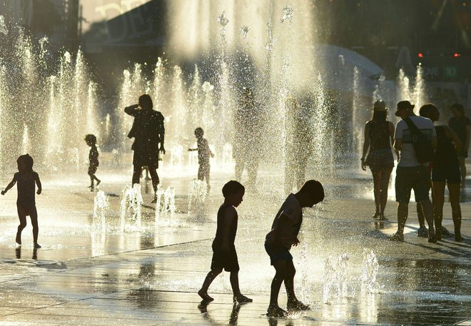 Otroci se hladijo ob vodnih fontanah v Montrealu. FOTO: Eva Hambach/AFP