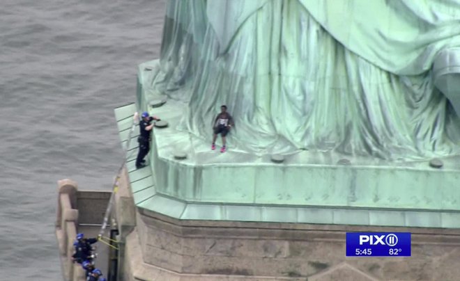 Turisti so morali zapustiti kip, medtem ko je ženska vztrajala pri nogah simbola svobode. FOTO: AP