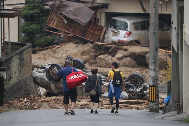 Na Japonskem že od četrtka močno dežuje, zaradi česar so poplavljene številne ceste in hiše, sprožilo se je tudi več zemeljskih plazov. FOTO: AFP