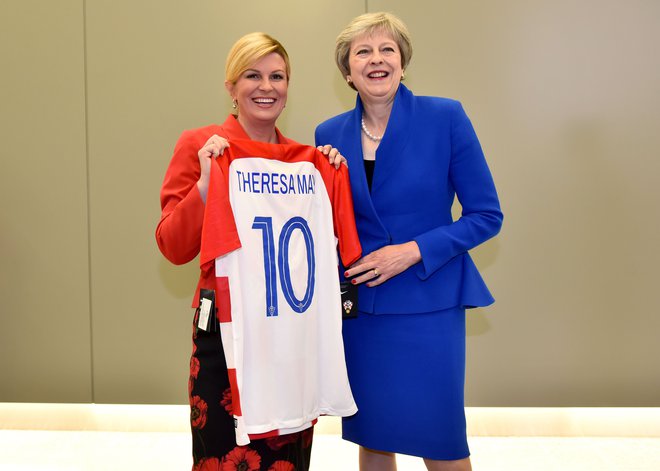 Pred polfinalnim dvobojem na SP med Hrvaško in Anglijo je hrvaška predsednica Kolinda Grabar-Kitarović (levo) britanski premierki Theresi May na vrhu Nata v Bruslju podarila hrvaški dres s številko 10. FOTO: AFP