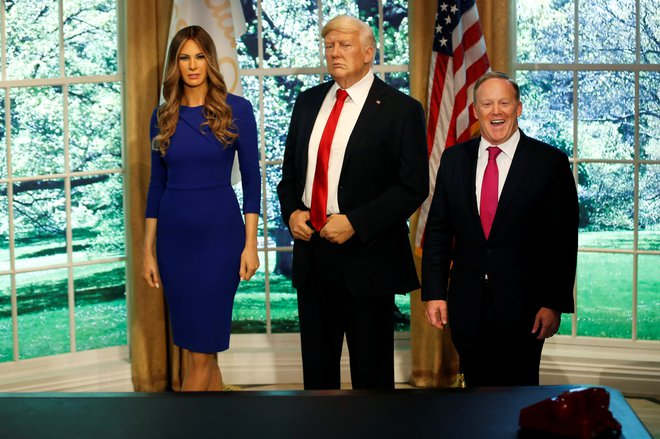 Nekdanji tiskovni predstavnik Bele hiše Sean Spicer pozira skupaj z voščenima figurama Melanie in Donalda Trumpa v muzeju voščenih lutk Madame Tussauds v New Yorku. FOTO: Reuters