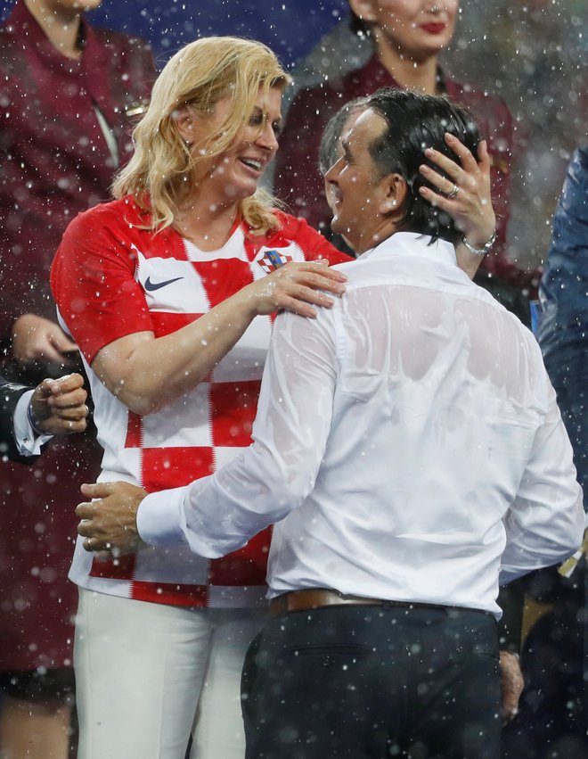 Od dežja premočena in prezebla hrvaška predsednica Kolinda Grabar-Kitarović je toplo čestitala selektorju Zlatku Daliću. Foto Reuters