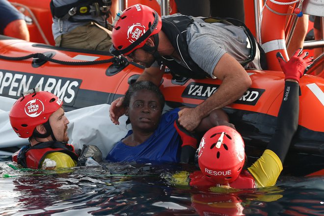 Člani organizacije Proactiva Open Arms rešujejo preživelo žensko. Dvema niso mogli pomagati. FOTO: Pau Barrena/AFP