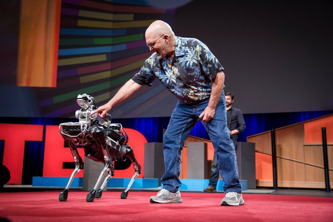 Marc Raibert ukazuje SpotMiniju, naj sede. FOTO: Boston Dynamics