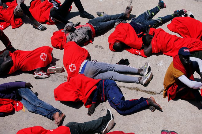 Migranti, ki so jih španske ladje potegnile iz vode nedaleč od Gibraltarja, med čakanjem v španskem pristaniškem mestu Tarifa. FOTO: REUTERS/Jon Nazca