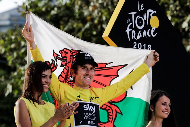 Tour de France 2018 winner Great Britain&#39;s Geraint Thomas (C) holds a Welsh flag as he celebrates his overall leader yellow jersey on the podium after the 21st and last stage of the 105th edition of the Tour de France cycling race between Houilles and Paris Champs-Elysees, on July 29, 2018. / AFP PHOTO / Thomas SAMSON Foto Thomas Samson Afp
