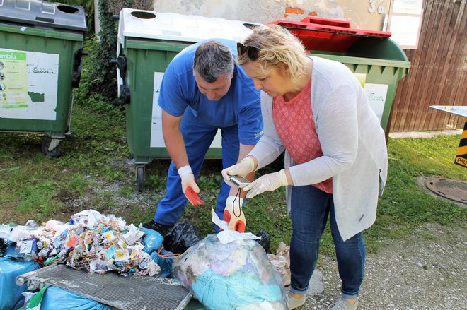 Delavec Simbia in inšpektorica Nataša Kos med brskanjem po odpadkih na Dobrni. FOTO: Simbio