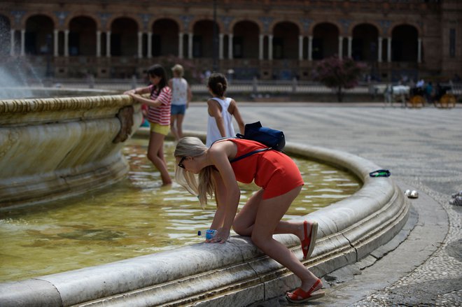 Ljudje iščejo vsako priložnost za osvežitev tudi v Sevilli, kjer je poleti zelo vroče. FOTO: AFP