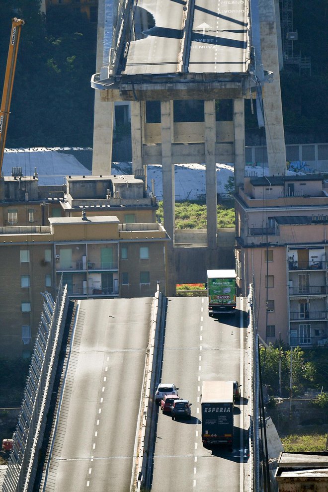 A truck is blocked at the end of the collapsed Morandi highway bridge in Genoa, northern Italy, Wednesday, Aug. 15, 2018. A bridge on a main highway linking Italy with France collapsed in the Italian port city of Genoa during a sudden, violent storm, sending vehicles plunging 90 meters (nearly 300 feet) into a heap of rubble below.  (Luca Zennaro/ANSA via AP)