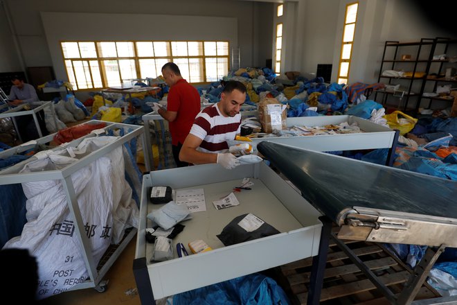 Zaposleni na pošti so v zadnjih dneh kupe pisem in paketov razvrščali v mestu Jeriho na Zahodnem bregu. FOTO: Mohamad Torokman/Reuters