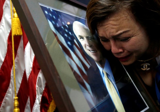 Američanka vietnamskega rodu Mai Tran žaluje za umrlim senatorjem Johnom McCainom na ameriškem veleposlaništvu v Hanoju. FOTO: Reuters