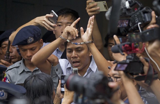 Reutersov novinarjev Kjav Soe Oo na poti iz sodišča v zapor. FOTO: AP Photo/Thein Zaw