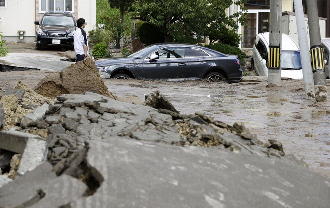 Ujeti avtomobili v mestu Sapporo na severnem delu Japonske. FOTO: Hiroki Yamauchi/Ap