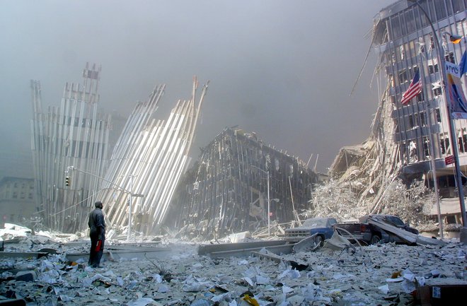 Med množico, ki se je umikala od porušenih dvojčkov, je bilo zlahka prepoznati tiste, ki so bili zelo blizu, saj so bili od glave do pete prekriti z belim prahom. FOTO: Doug Kanter/Afp