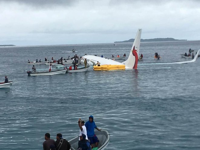 Takole so čolni prispeli do letala, ki je pristalo v vodi ob Mikroneziji. FOTO: James Yaingeluo/Reuters