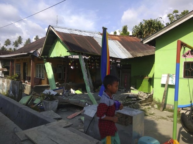 Indonezijska agencija za nesreče poroča o zrušenih objektih, cunami z 1,5 metra visokimi valovi je odnašal hiše. FOTO: AFP