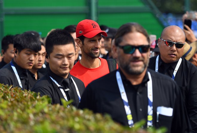 Novak Đoković (v Šanghaju na poti na trening ob številnih varnostnikih) je nared za zmagoviti finiš sezone. Foto: AFP