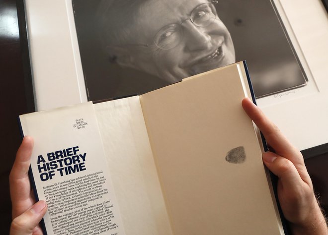 Knjiga Kratka zgodovina časa s prstnim odtisom avtorja Stephena Hawkinga. FOTO: Frank Augstein/AP