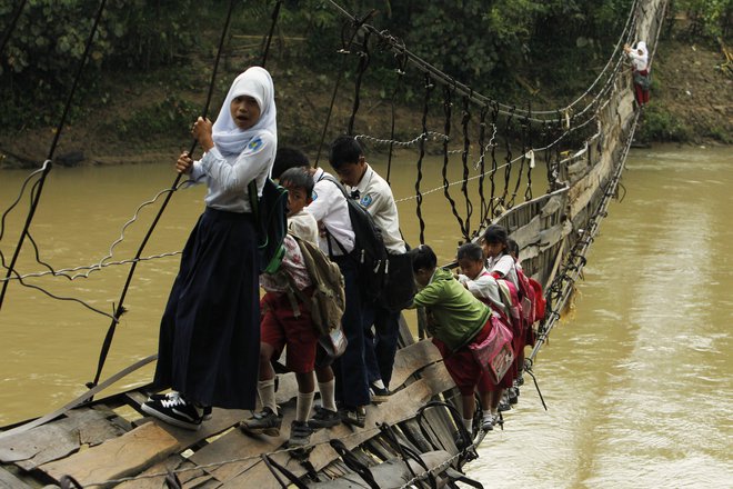 &nbsp;Otroci morajo po uničenem visečem mostu, ki je edina možna pot do šole v odročni indonezijski provinci.&nbsp;Foto Beawiharta Beawiharta Reuters