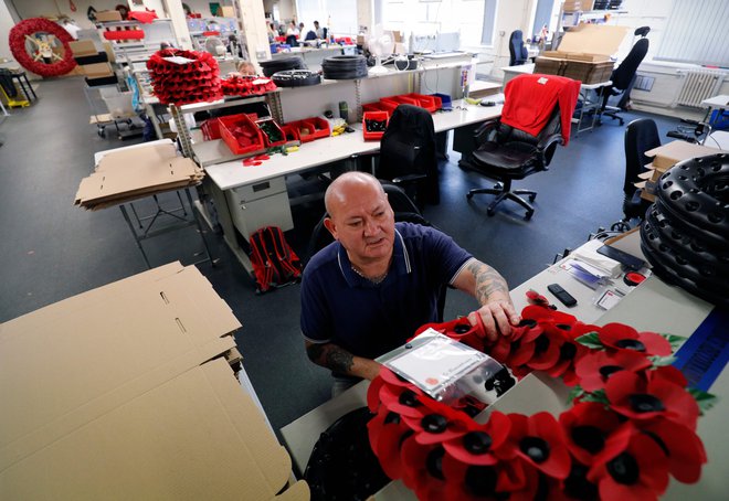 V londonski tovarni so vojni veterani vse leto izdelovali umetne makove cvetove, ki jih ob zaznamovanju konca prve vojne nosi na milijone ljudi. Foto AFP