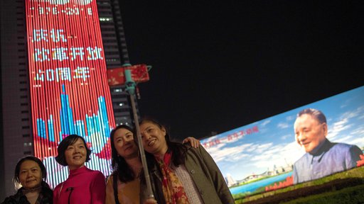 Ob obletnici začetka kitajskih reform in odpiranja proti svetu se ljudje fotografirajo pred panojem reformatorja Deng Xiaopinga. FOTO: AFP