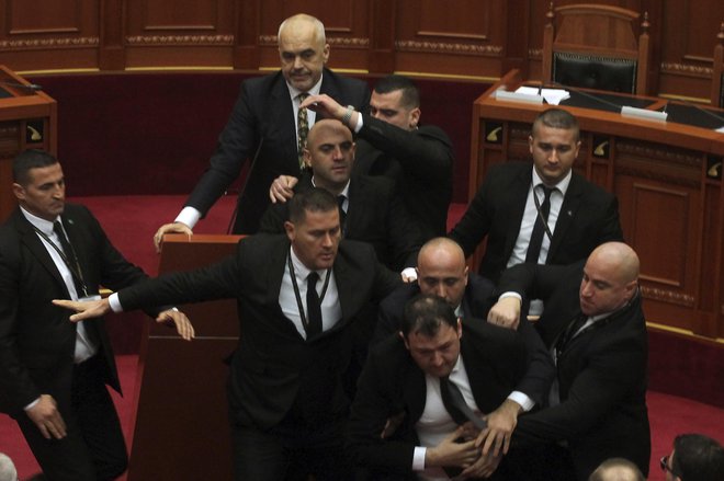Varnostniki so odstranili iz parlamenta opozicijskega poslanca Endrija Hasa, ki je skušal premierja Edija Ramo obmetavati z jajci. FOTO: AP