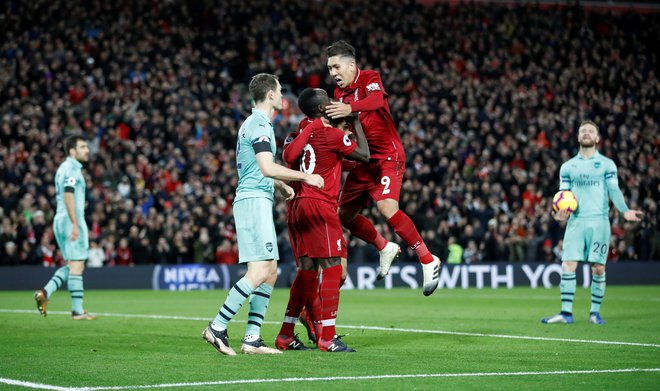 Roberto Firmino je takole naskočil&nbsp;Sadia Maneja in Mohameda Salaha, potem ko so se vsi trije vpisali med strelce na zadnjem derbiju Liverpoola z Arsenalom. FOTO: Reuters