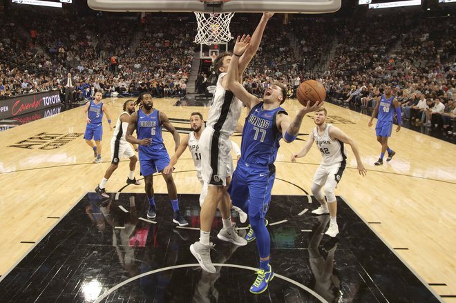 Luka Dončić v dvoboju s Paujem Gasolom, levo Marco Belinelli, desno Davis Bertans. FOTO: Reuters