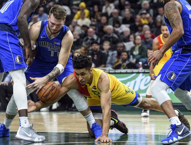 Luka Doncic se je takole boril za žogo z Malcolmom Brogdonom. FOTO: Reuters