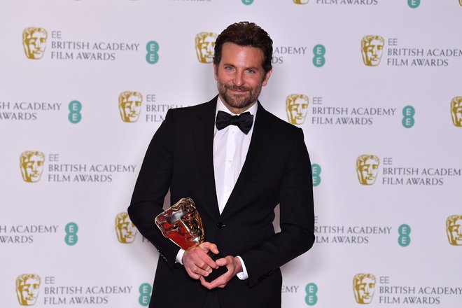 Bradley Cooper z nagrado za najboljšo filmsko glasbo. FOTO: Ben Stansall/Afp