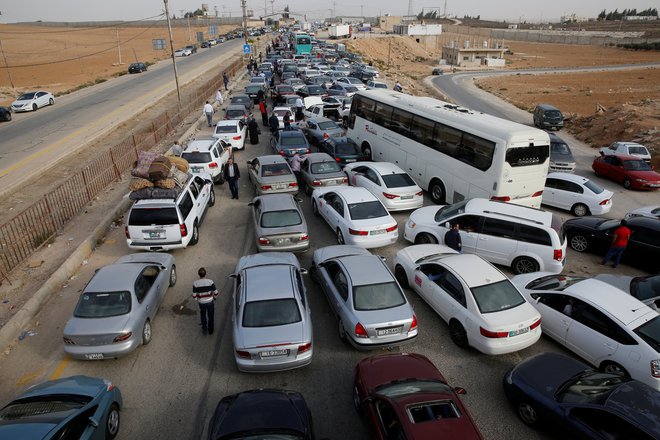 Domačini in trgovci potrpežljivo čakajo na vstop v državo. FOTO: Muhammad Hamed/Reuters