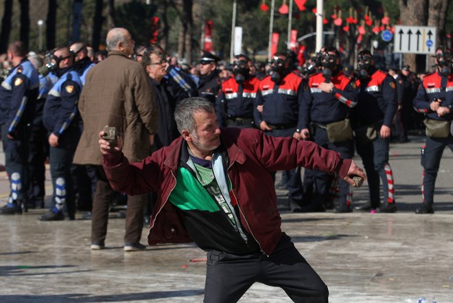 Protestniki pred vladnim poslopjem so policiste obmetavali s kamenjem. FOTO: Florion Goga/Reuters