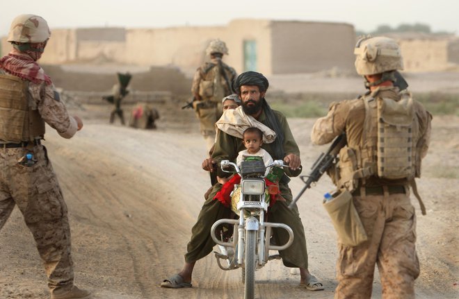 Večerna patrulja marincev zaustavlja in pregleduje domačina na cestni kontrolni točki v okroju Garmir, v provinci Helmand v Afaganistanu. FOTO: Jure Eržen