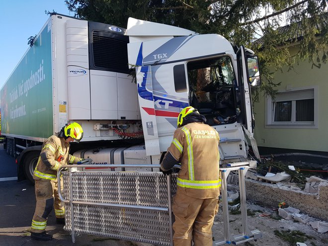 Tovornjak je po navedbah policijske uprave nenadzorovano zapeljal skozi križišče, podrl semafor ter trčil v betonsko ograjo in smreko ob križišču. FOTO: CZR Domžale