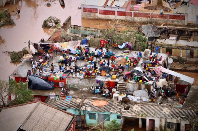 Ljudje tudi več dni po divjanju tropskega ciklona čakajo na rešitev na strehah. FOTO: AFP