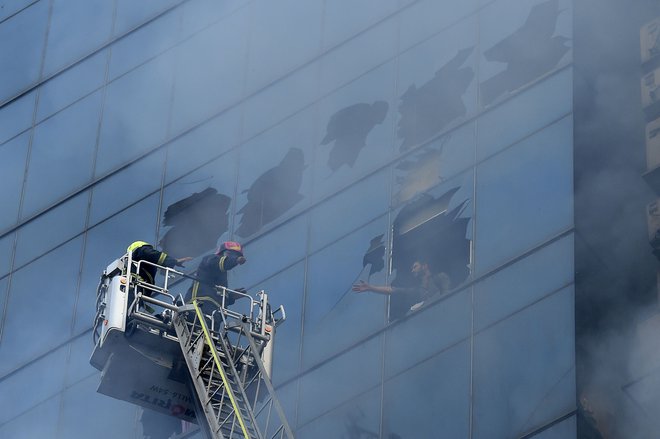 Požar je v stolpnici z izjemno pomanjkljivimi protipožarnimi ukrepi presenetil več sto uslužbencev. FOTO: Munir Uz Zaman/AFP