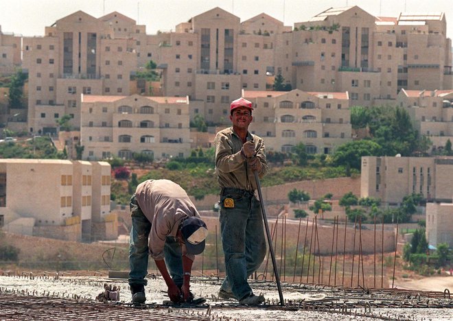 Palestinska delavca ob gradnji naselja za judovske priseljence v kraju Ma&#39;ale Adumim na Zahodnem bregu. FOTO: Rula Halawani/Reuters