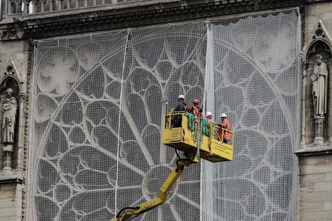 V začetku tedna so zaradi napovedanega dežja Notredamsko katedralo prekrili s ponjavo. FOTO: Kenzo Tribouillard/AFP