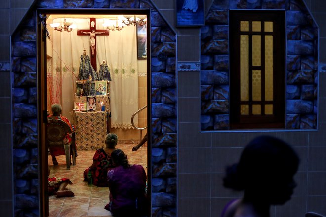 Ljudje molijo v hiši blizu cerkve sv. Antona.  FOTO: Danish Siddiqui/Reuters