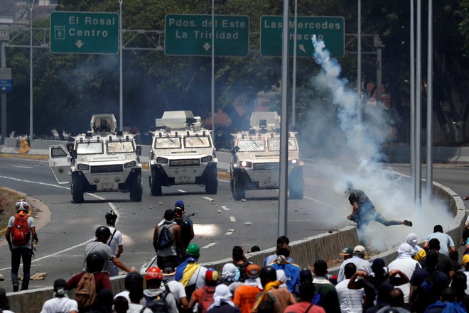 Opozicijski demonstranti so se spopadli z varnostnimi silami v bližini vojaškega letališča La Carlota v Caracasu. FOTO: Reuters