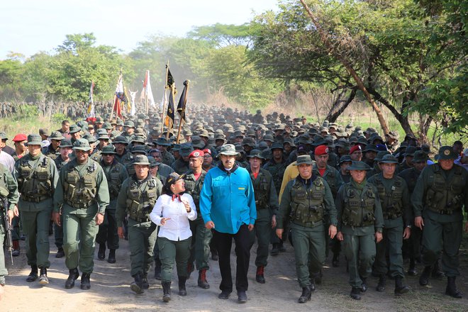 Venezuelski predsednik Maduro hodi ob boku obrambnega ministra in predstavnikov vojske med njegovim obiskom vojaškega oporišča v El Pau. FOTO: Reuters