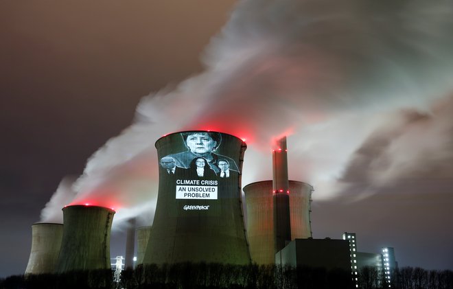 Aktivisti Greenpeaca so na termoelektrarno v bližini Kölna projicirali ključne figure, ki lahko pospešijo zmanjšanje izpustov: kanclerko Angelo Merkel, gospodarskega ministra Petra Altmaierja, vodjo SPD Andreo Nahles ter ministra za transport Andreasa Scheuerja. FOTO: Reuters